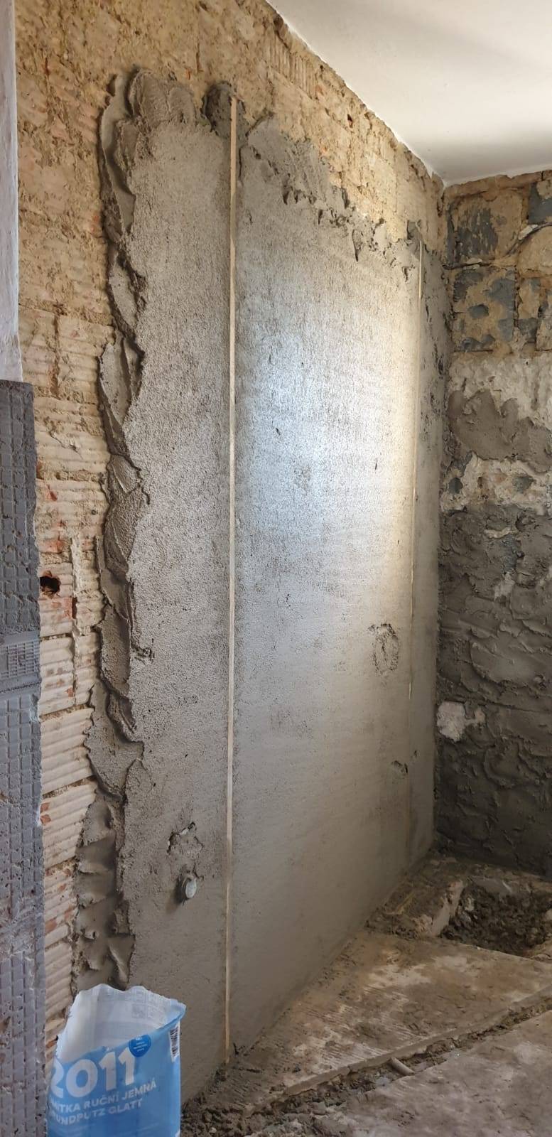 Odkrytá stěna koupelny během bouracích prací